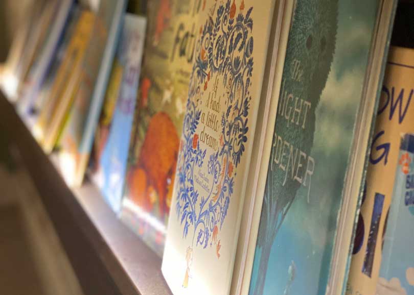Close up of children's books on a wall rack in Wise Wonder Enrichment