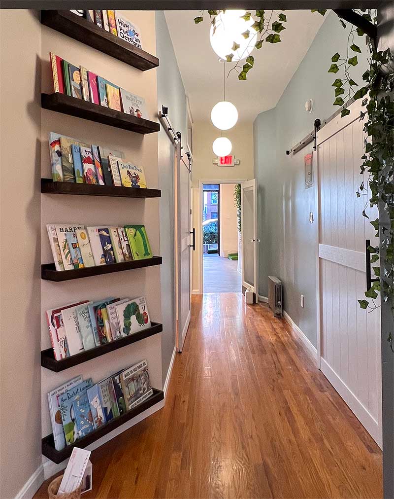 Hallway with book-lined shelves in Wise Wonder Park Slope